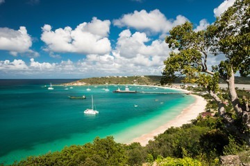 Colorful beach bungalows lining a turquoise bay in Anguilla.